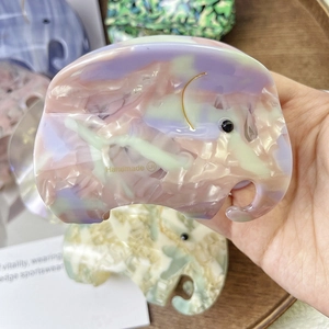 Close-up of handmade elephant acetate hair claw with pastel marble texture finish