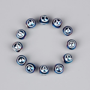 Vista macro di dodici perline zodiacali blu scuro con simboli bianchi in cerchio