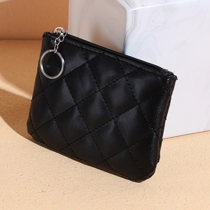 Quilted black mini coin purse with silver zipper and keychain on marble background