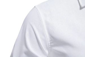 Macro detail of the high-density fabric texture and durable stitching on white cotton shirt