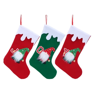 Detailed view of red and green felt Christmas stockings with plush trim and faceless gnome