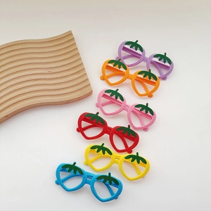 Close-up of strawberry-shaped kids' plastic toy glasses frames in six vibrant colors