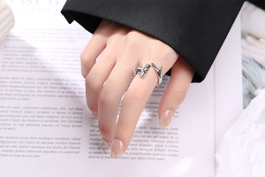 Close-up of adjustable silver antler-style open ring on finger with polished finish