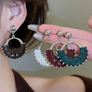 Detailed view of retro leather circular stud earrings in black, white, red, and green