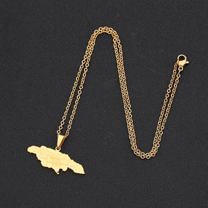 Golden stainless steel Jamaica map pendant necklace with engraved parish names on dark surface