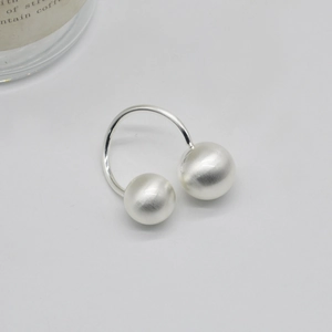 Minimalist silver brushed metal open ring with double spherical design on white background