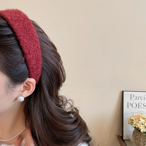 Close-up of deep red plush headband featuring textured bouclé fabric for autumn look