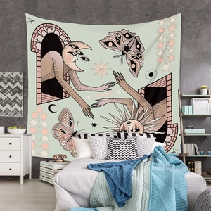 Detail of surreal boho tapestry with sun and moon illustration over a modern bed