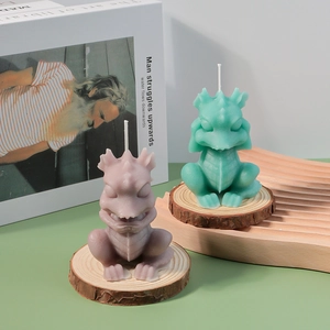 Detail of dragon-shaped candles in lavender and mint green showing intricate scales