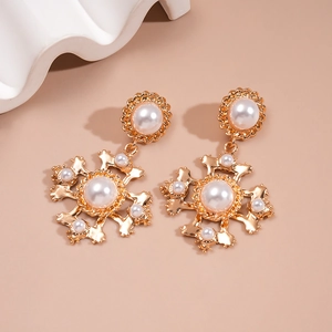 Retro gold alloy cross earrings with pearls in a palace style on beige background
