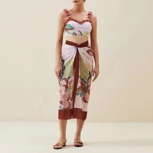 Detail of tropical floral print on a pink two-piece vacation set with ruffled shoulder straps