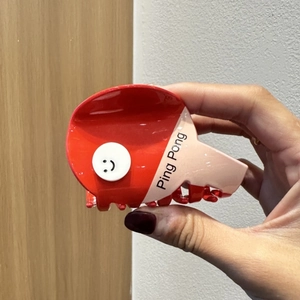 Detailansicht der pink-roten Tischtennisschläger-Haarklammer mit süßem Smiley-Gesicht
