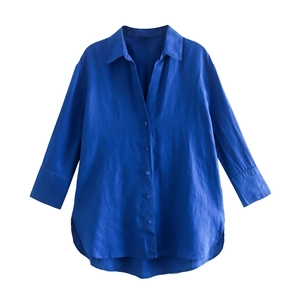 Dettaglio camicia in lino blu reale a maniche lunghe con spacco laterale e orlo curvo