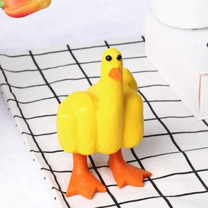 Detail of yellow resin duck figurine with textured surface on a checkered cloth