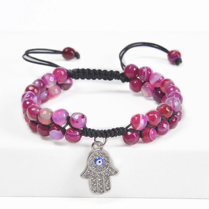 Detail showing double-layered purple beaded bracelet with Hamsa Hand and Evil Eye charm
