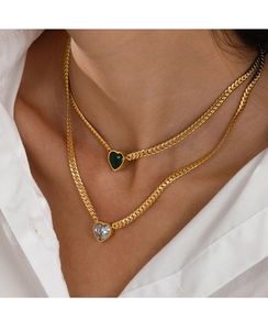 Detail of gold double-layer necklace with green and clear heart pendants on snake chain