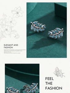 Detailed view of vintage leaf-shaped earrings with turquoise blue beads on green velvet