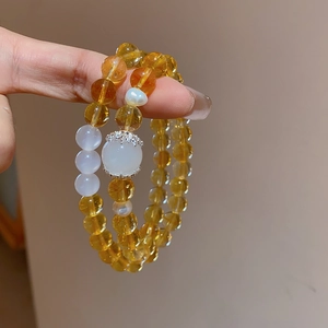 Close-up of yellow citrine and white chalcedony beads on a double-layer bracelet