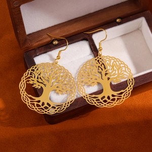 Polished gold Tree of Life drop earrings on a warm orange velvet display box