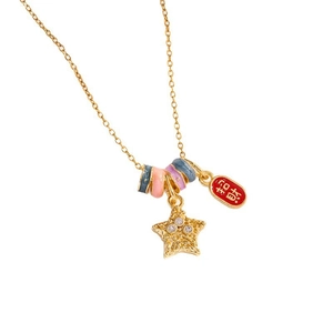 Gold charm necklace with star pendant and red lucky charm on a minimalist white background