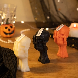 Detailed view of Halloween skull candles in white, black, and orange colors