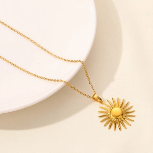 Collana chic con ciondolo a sole dorato su uno sfondo minimalista in ceramica bianca