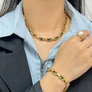 Detail showing 18K gold plated necklace and bracelet set with green gemstone details