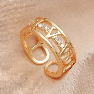 Macro shot of gold V-shaped open ring with cubic zirconia stones on silk fabric