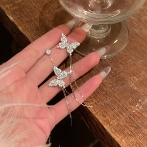 Detailed view of silver butterfly tassel earrings with sparkling zircons and snake chains