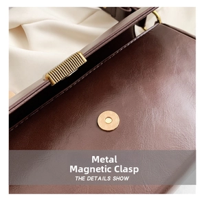 Nahaufnahme einer braunen Ledertasche mit hochwertigem goldener Magnetverschluss-Detail