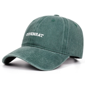Detailed view of COVENRAT white letter embroidery on a dark green washed cotton baseball cap