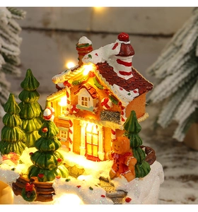 Detail eines leuchtenden Weihnachtshauses mit warmem LED-Licht und Lebkuchenmann