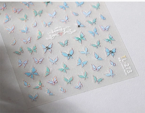 Macro shot of TL-273 butterfly nail stickers with light blue wings and crystal accents