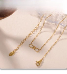 Détail du collier noeud doré montrant le placage PVD et l'incrustation de zircon