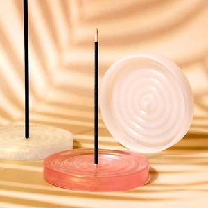 Close-up of circular silicone incense burner mold with concentric texture and three color options