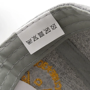 Detail of grey baseball cap label showing 100 percent polyester and made in China text