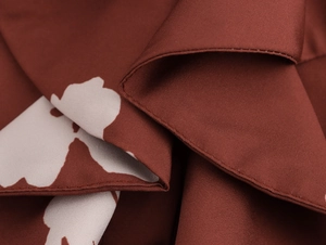 Vue macro détaillée du tissu floral caramel et de la couture de précision à double aiguille