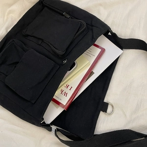 Internal view of the black canvas bag showing storage space for books and a mobile phone