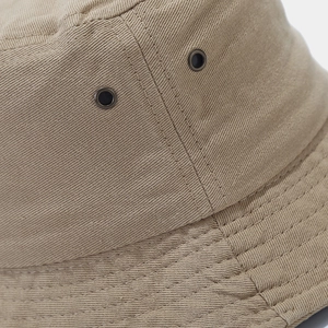 Dettaglio del cappello pescatore in cotone kaki con occhielli in metallo e cuciture