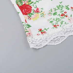 Macro shot of floral print fabric with delicate white lace trim on the garment edge