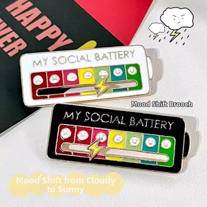 Macro detail of social battery enamel pins with sliding metal lightning bolt indicator