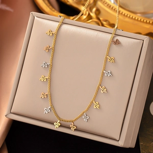 Detail view of gold and silver snake pendants on a sleek titanium steel necklace
