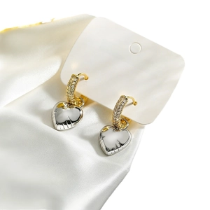 Asymmetric heart and star drop earrings in gold finish on white silk background