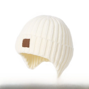 Detail of white ribbed knit winter beanie with ear flaps and brown leather label