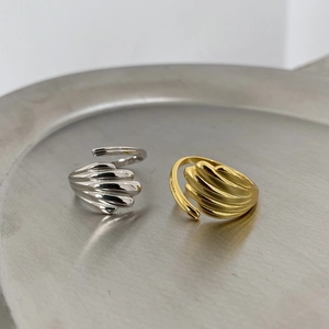 Close-up of gold and silver sterling silver rings with shell texture on a metal tray