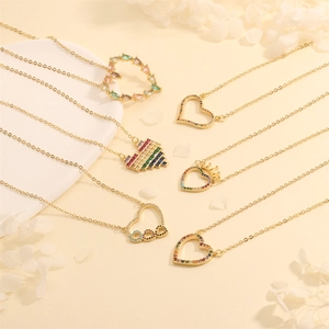 Detail view of heart-shaped gold necklaces with colorful zircons and intricate hollow designs