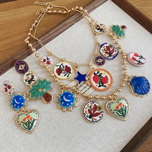 Bohemian gold jewelry set with colorful enamel heart and sun pendants on linen display