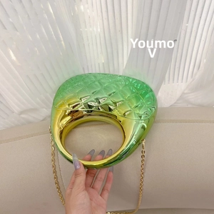 Detail of green-gold gradient shell bag with diamond pattern and gold chain strap