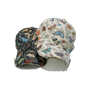 Detail of tapestry baseball caps with colorful butterfly embroidery and frayed brim