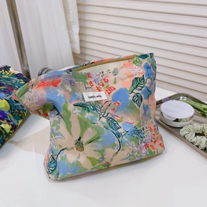Floral cotton makeup bag with green flower patterns and metal zipper on white background